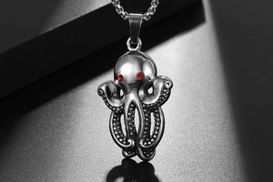 Macro shot of titanium steel octopus pendant with red gemstone eyes and textured tentacles