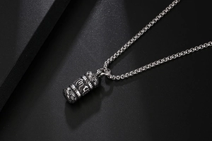 Detailed close-up of retro titanium steel cylinder pendant with lotus mantra engravings