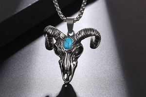Detail of ram skull pendant with turquoise stone inlay on vintage steel chain