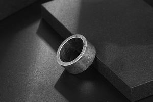 Close-up of wide men's titanium steel ring with vintage brushed silver finish