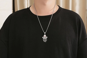 Close-up of retro octopus pendant with red gemstone eyes on a steel box chain