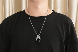 Détail d'un homme portant un collier avec pendentif ailes d'ange en acier