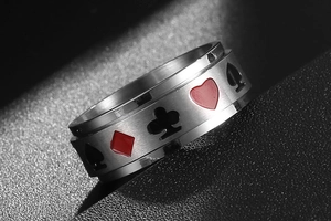 Détail macro d'une bague spinner rotative en acier avec gravures des motifs de poker
