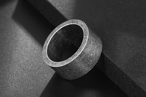 Macro side view of a wide vintage silver ring with textured industrial matte finish