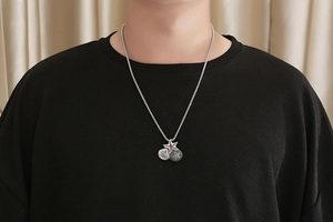 Close-up of vintage titanium starfish and shell pendants on a male model neck