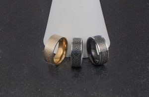 Detailed view of black, gold, and silver Celtic knot rings on cone display stands
