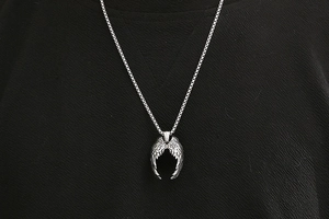 Gros plan du pendentif ailes d'ange en acier titane avec texture de plumes détaillée
