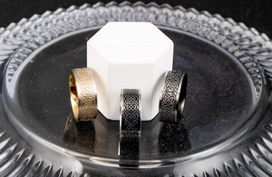 Macro shot of men's wide punk rings with Celtic knot patterns in black and silver finish