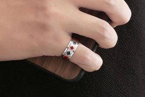 Détail de la bague rotative en acier titane avec motifs de pique et cœur noirs et rouges