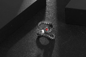 Macro shot of octopus tentacle steel ring with red gemstone in vintage finish