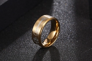 Gros plan détaillé d'une bague dorée brossée avec gravures de guitare et arbre de vie