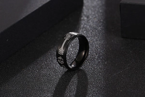 Détail d'une bague noire en acier inoxydable avec motifs de guitare gravés au laser