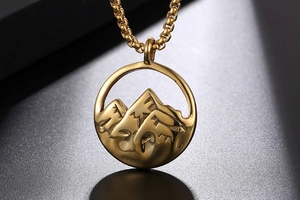 Gros plan du pendentif circulaire avec relief de montagne dorée et textures