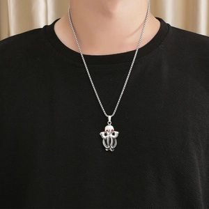 Vintage octopus pendant necklace in titanium steel with red gemstone eyes on a male model