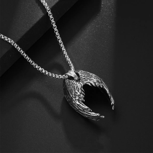 Pendentif ailes d'ange en argent avec chaîne maille vénitienne sur fond noir texturé