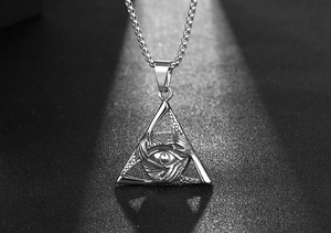 Macro shot of silver titanium steel triangle pendant with All-Seeing Eye relief detail