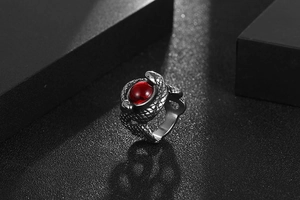 Detail of vintage snake ring in titanium steel with a ruby red stone in punk gothic style