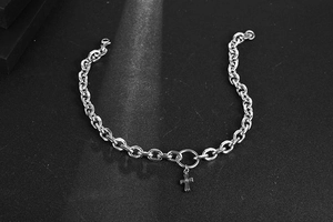 Macro view of silver stainless steel curb chain with a solid 3D cross pendant detail