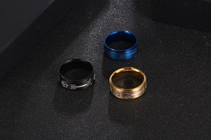 Détail de trois bagues en acier inoxydable noir, bleu et doré avec gravure de guitare