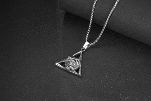 Macro shot of retro triangular titanium steel pendant with Evil Eye engraving and chain