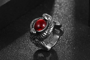 Macro view of gothic double snake ring with intricate scales and large red gemstone