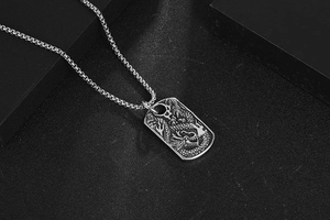 Macro view of vintage silver dragon relief pendant with durable square box chain necklace