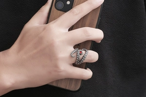 Detailed view of vintage octopus tentacle steel ring with red zircon stone on finger