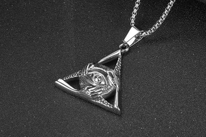 Detailed close-up of a silver triangle Evil Eye pendant on a steel chain necklace