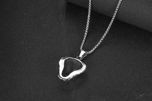 Close-up of a dual-tone cobra head pendant with a silver box chain on black background