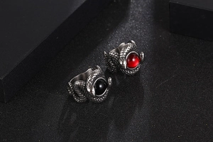 Detail of gothic dual snake rings with red and black stones and scaled texture