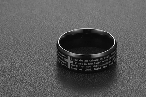 Macro detail of black stainless steel ring with laser engraved cross and Bible scripture