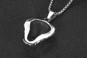 Macro shot of a geometric silver animal pendant with a stainless steel box chain