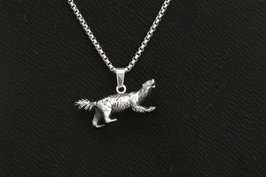 Macro shot of a vintage stainless steel wolf pendant with detailed hair texture