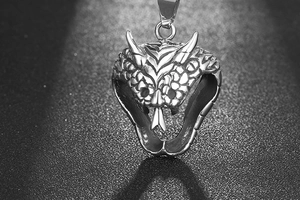 Macro shot of cobra head pendant featuring detailed scales and gothic steel texture