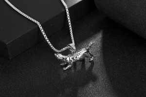 Macro view of a wild animal pendant on a stainless steel box chain for men