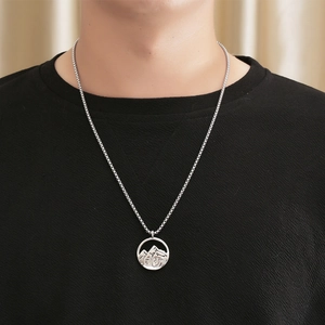 Collier pendentif montagne en acier inoxydable argenté sur mannequin portant un t-shirt noir