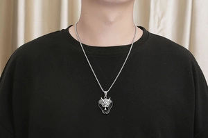 Close-up of vintage silver owl head pendant with red eyes on a thick box chain for men
