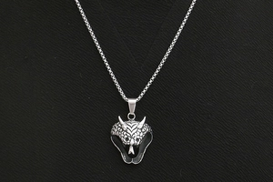 Detailed close-up of a silver cobra head pendant with intricate scale textures on a box chain