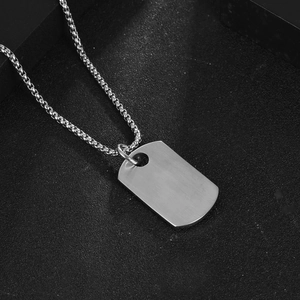 Minimalist silver stainless steel military dog tag necklace with a box chain on black background