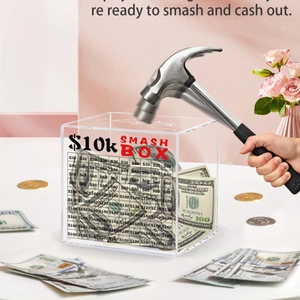 Large clear acrylic $10,000 savings challenge box being smashed with a hammer to cash out