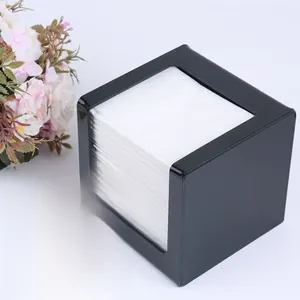 Detail view of a black square acrylic tissue box with polished finish and white napkins