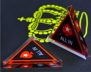 Macro detail of triangle acrylic poker All In chip with red spade design and sharp edges