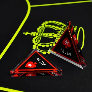 Black acrylic double-sided All-In poker dealer chip with red spade icon on table