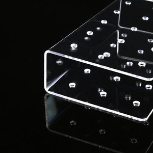 Macro view of transparent acrylic lollipop stand with 15 holes on a black background