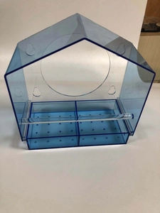 Detail of blue acrylic bird feeder featuring dual feeding trays and clear perch