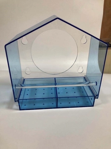 Close-up of clear acrylic bird feeder with feed trays and bird perch details