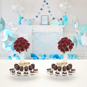 Three-tier clear acrylic dessert stand showcasing cupcakes and roses in a party setting