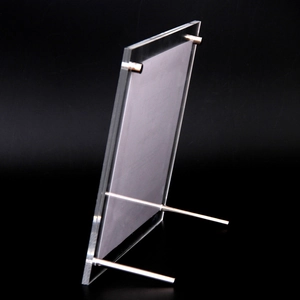 Modern A4 acrylic photo frame with silver metal support studs on black background