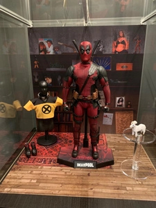 Detailed view of Deadpool action figure set with accessories on hexagonal base