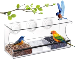 Detailed view of clear acrylic bird feeder with three feeding slots and suction cups